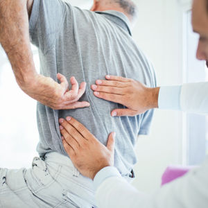 Læge undersøger patients ryg